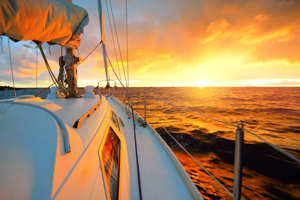 夕日の海で白いヨットセーリング デッキから弓 マスト 帆への眺め 壮大な雲の風景 嵐の後に輝く黄金の雲と劇的な空 レーシング スポーツ レジャー活動 — ストック写真