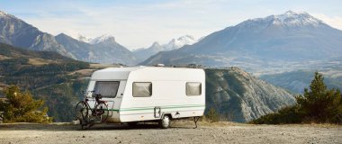 Karavan karavanı, bisiklet ve araba bir dağın tepesine park edilmiş. Fransız Alpleri 'nde, Lac de Serre-Poncon Gölü yakınlarında. Ulaşım, karavan, karavan, yol gezisi, kamp, turizm, eğlence, yaşam tarzı
