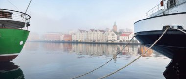 Şehir merkezindeki bir rıhtıma demirlemiş yeşil eğitim gemisi. Stavanger seti, Norveç. Seyahat yerleri, turizm, turizm, gezi, yelkenli yarışı, keşif, araştırma, iş, geleneksel zanaat.