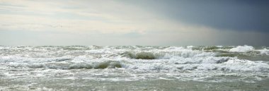 Fırtına sonrası karanlık dramatik bulutların altında Baltık Denizi. Letonya 'da sızıntı var. Destansı deniz manzarası. Kasırga, fırtına, sert hava, meteoroloji, ekoloji, iklim değişikliği, doğal olaylar