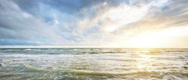 Gün batımında fırtınadan sonra Baltık Denizi. Letonya 'da sızıntı var. Renkli parlayan bulutlar. Dalgalar ve su sıçramaları. Destansı deniz manzarası. Kasırga, fırtına, dönek hava, meteoroloji, ekoloji