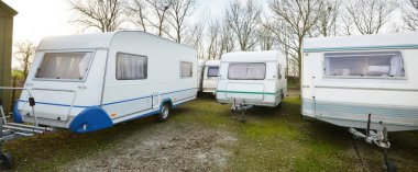 Yeşil çimlere park edilmiş karavan karavanları. Kış. Yerel iş, şirket, hizmet kavramı. Hollanda 'da. Karavan, karavan, ulaşım, yolculuk, seyahat, eko-turizm, yaşam tarzı, konfor