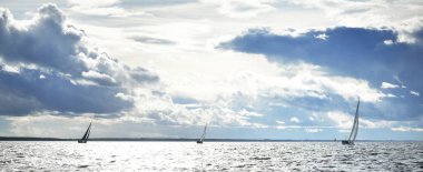 Yelkenli yat yarışı. Modern yelkenli dalgalar arasında yarışıyor. Fırtınadan önce dramatik gökyüzü. Muazzam bulut manzarası. Kuzey Almanya, Kiel