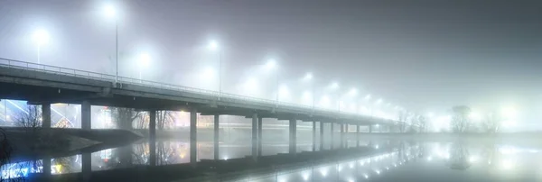 夜雾中灯火通明的空桥的低角度视图 灯笼特写 对称反射在水面上 天然的镜子 Daugava河 拉脱维亚里加 — 图库照片