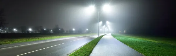 Camino Bicicleta Iluminado Vacío Cerca Carretera Una Niebla Por Noche — Foto de Stock