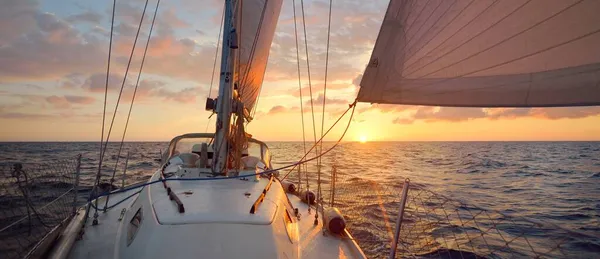 日落时 白色的帆船在开阔的海面上航行 单人驾驶一艘34英尺长的游艇 桅杆和帆的近景 五彩斑斓的云彩 — 图库照片