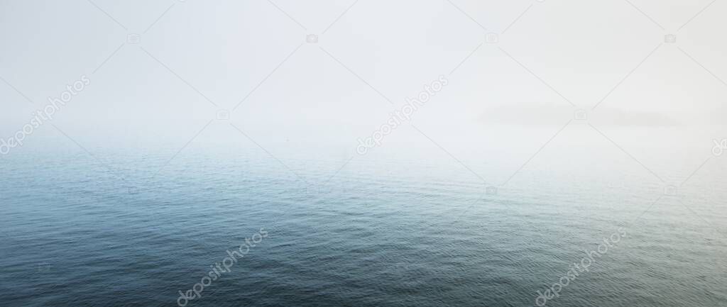 Panoramic view of the North sea in a fog. Norway. Still water surface texture. Blue, azure, turquoise colors. Abstract natural pattern, background, wallpaper. Graphic resources, copy space