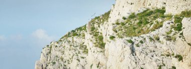 Kayalık kıyılar (uçurumlar) yakın çekim, yelkenli teknenin manzarası. Frioul takımadaları, Akdeniz, Marsilya Körfezi, Fransa. Seyahat yerleri, ulusal dönüm noktaları, geziler, tatiller.