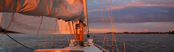 日没時にバルト海を航海する白いヨット 水の中に反映輝く雲と劇的な空 太陽を沈める 壮大な海の景色 旅行先 クルーズ スポーツ レクリエーションのコンセプト — ストック写真
