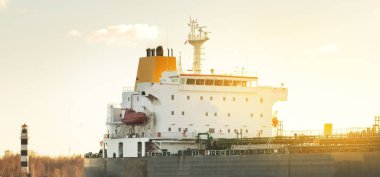 Büyük bir kargo gemisi dramatik günbatımı gökyüzünün altında limana demir attı. Destansı deniz manzarası. Nakliye, küresel iletişim, teslimat, yakıt ve güç üretimi, endüstri, lojistik