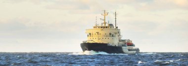 Sovyet buzkıranı dramatik günbatımı bulutları altında açık denizde. Yük taşımacılığı, küresel iletişim ve güvenlik, yakıt ve güç üretimi, sanayi, lojistik, araştırma, keşif