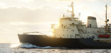 Sovyet buzkıranı dramatik günbatımı bulutları altında açık denizde. Yük taşımacılığı, küresel iletişim ve güvenlik, yakıt ve güç üretimi, sanayi, lojistik, araştırma, keşif