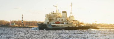 Sovyet buzkıranı deniz fenerinin yanında dramatik günbatımı gökyüzünün altında. Yük taşımacılığı, küresel iletişim ve güvenlik, yakıt ve güç üretimi, sanayi, lojistik, araştırma, keşif