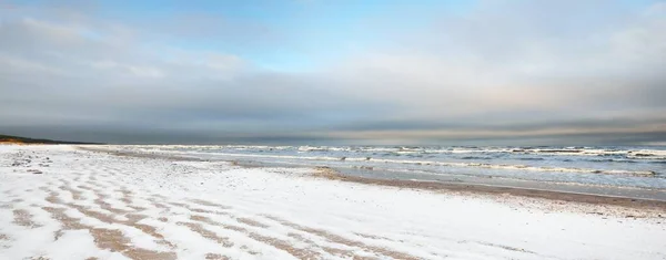 夕暮れ時には雪に覆われたバルト海の海岸からの眺め ラトビアのリガ湾 カラフルな劇的な雲の風景 ひどい天気 波と水が飛び散った 冬の観光 地球温暖化のテーマ — ストック写真