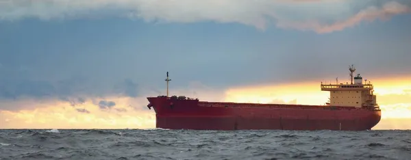 Groot Rood Vrachtschip Varen Een Open Zee Onder Donkere Zonsondergang — Stockfoto
