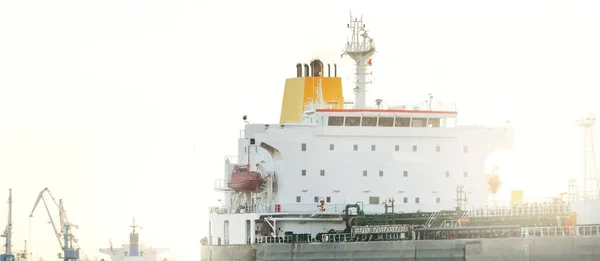 大規模な貨物船が劇的な日没の空の下で港に停泊した 壮大な海の景色 貨物輸送 グローバル通信 燃料および発電 — ストック写真