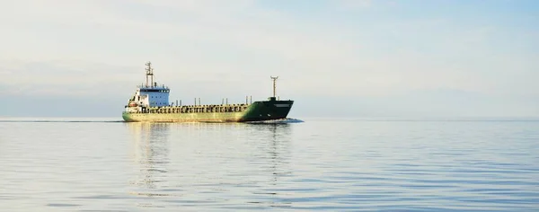 日没時には大規模な緑の貨物船が外洋を航行する カラフルな輝く雲 暖かい日差し コンセプトイメージ 貨物輸送 ビジネス グローバル通信 — ストック写真