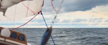 Gün batımında açık denizde yelken açmak. Güverteden pruvaya, direğe ve yelkenlere yakın görüntü. Dramatik fırtınalı gökyüzü, kara bulutlar, kış kasırgası, sert hava. Destansı deniz manzarası. Kuzey denizi, Norveç