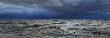 Günbatımında bir yelkenliden Kuzey Denizi manzarası. Çarpıcı fırtınalı gökyüzü, kara bulutların arasından güneş ışınları. Destansı deniz manzarası. Kışın şiddetli kasırga. Norveç. Görüntü, iklim değişikliği, ekoloji