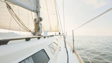 Açık denizde, açık bir günde beyaz bir yat. Güverteden pruvaya, direğe ve yelkenlilere kadar bir manzara, ekipmanları yakın çekimde donatmak. Yaz Atlantik 'i İspanya ve Afrika yakınlarında geçiyor.