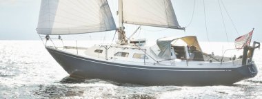 Açık bir Baltık Denizi 'nde yelkenli mavi bir yat, yakın plan. Dramatik bir gökyüzü. Riga Körfezi, Letonya. Gezi, spor, eğlence, boş zaman aktiviteleri.