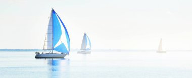 Yelkenli yat yarışı. Modern yelkenliler mavi yelkenli ile yarışıyor. Açık bir yaz günü. Kiel, Almanya. Spor ve eğlence, ulaşım, özel Wessel, tatiller