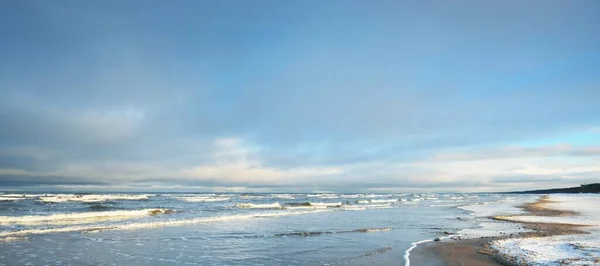 日没時には雪に覆われたバルト海の海岸からの眺め ラトビアのリガ湾 劇的な青空 ひどい天気 波と水が飛び散った 冬の観光 地球温暖化のテーマ — ストック写真