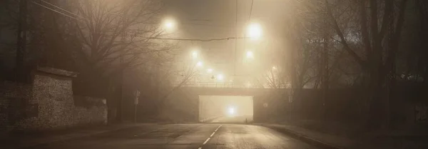 Geceleyin Sisli Boş Aydınlık Asfalt Bir Yol Köprü Arka Planda — Stok fotoğraf