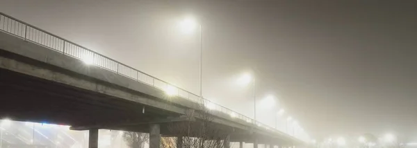 夜霧の中で照明された空の道路橋の低角度ビュー 提灯を閉じます パノラマ画像 — ストック写真