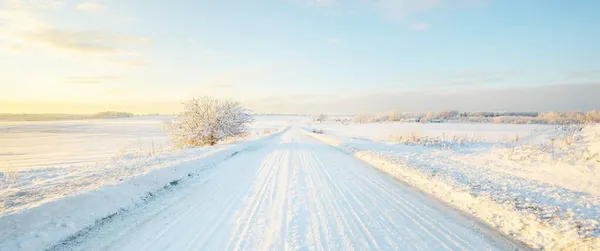 Země Silnice Přes Zasněžené Pole Sněhové Bouři Při Západu Slunce — Stock fotografie