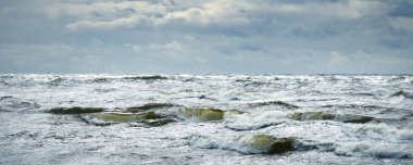 Fırtınadan sonra dramatik günbatımı bulutları altında Baltık Denizi. Dalgalar yakın çekim. Destansı deniz manzarası. Kasırga, fırtına, sert hava, meteoroloji, ekoloji, iklim değişikliği, doğal olaylar