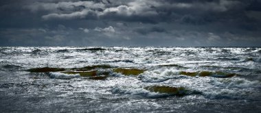 Fırtına sonrası karanlık dramatik bulutların altında Baltık Denizi. Destansı deniz manzarası. Kasırga, fırtına, sert hava, meteoroloji, ekoloji, iklim değişikliği, doğal olaylar