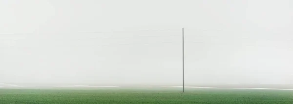 Grünes Landwirtschaftliches Feld Unter Düsterem Himmel Dichten Nebel Neuschnee Auf — Stockfoto