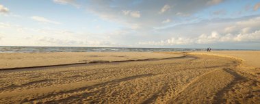 Destansı kümülüs bulutları, fırtınadan sonra kumlu Baltık deniz kıyısında. Kuru nehir, yakın çekim kum dokusu. - Letonya. Dramatik bir gökyüzü. Ekoloji, çevre koruma, kararsız hava, iklim değişikliği