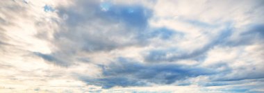 Süslü bulutlar. Dramatik bir gökyüzü. Destansı fırtına bulutları. Yumuşak güneş ışığı. Panoramik görüntü, doku, arkaplan, grafik kaynakları, tasarım, kopyalama alanı. Meteoroloji, cennet, umut, barış kavramı
