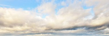 Süslü bulutlar. Dramatik bir gökyüzü. Bulutlar. Yumuşak güneş ışığı. Panoramik görüntü, doku, arkaplan, grafik kaynakları, tasarım, kopyalama alanı. Meteoroloji, hava, iklim, cennet, umut, barış kavramları