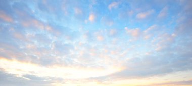 Açık mavi gökyüzü. Pembe ve altın rengi sirrus ve kümülüs bulutları fırtına üstüne, yumuşak güneş ışığı. Dramatik gün batımı bulutları. Meteoroloji, cennet, barış, grafik kaynakları, pitoresk panoramik manzara