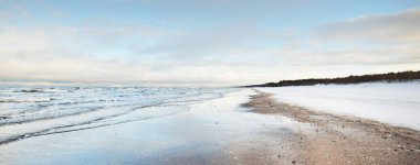Gün batımında donmuş Baltık Denizi kıyısı, kar dokusu yakın çekim. Dramatik bir gökyüzü. Resimli kış manzarası. Mevsimler, doğa, ekoloji, çevre, iklim değişikliği, küresel ısınma. Panorama, boşluğu kopyala