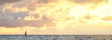 Gün batımında fırtınadan sonra Baltık Denizi kıyısında parlak pembe kümülüs bulutlarıyla dolu açık bir gökyüzü. Dramatik bulut manzarası. Sıcak altın güneş ışığı. Resimli bir manzara var. Huysuz hava