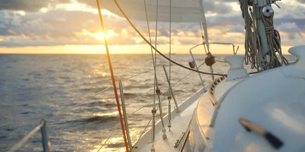 夕日の海でヨットセーリング デッキ マスト 帆の近くの景色 雨の後に澄んだ空 劇的な輝く雲 黄金の太陽の光 波と水のスプラッシュ サイクロン 叙事詩の海景 — ストック写真