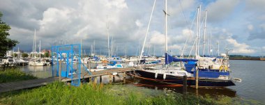 Zarif ve modern yelkenliler ve kesiciler yat limanında bir rıhtıma demirlediler. Yaz tatilleri, turizm, gezi, eğlence, spor, eğlence aktivitesi, aile, yaşam tarzı.