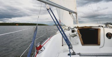 Beyaz yat gün batımında denize açılacak. Güverteye bak, direk, yay. 9 metre İsveçli seyyar yelkenli. 