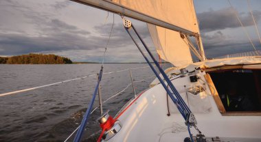 Beyaz yat gün batımında denize açılacak. Güverteye bak, direk, yay. 9 metre İsveçli seyyar yelkenli. 