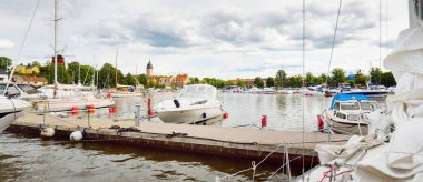 Yatlar, tekneler ve kesiciler gün batımında yat limanında demirlemiş..