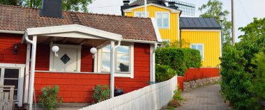 Sahte kırmızı boyayla boyanmış geleneksel İsveç evleri. Döşemeli çatılar. Boş sokak. 