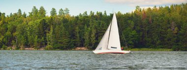 Açık bir günde beyaz yelkenli tekneyle denize açılmak. Yaz tatilleri, ulaşım, turizm, gezi, dinlenme, spor, eğlence aktivitesi, yarış, yelkencilik, yaşam tarzı.