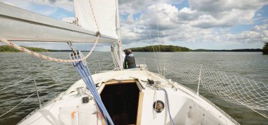 Fırtınadan sonra beyaz yat yola çıkıyor. Direk görüntüsü, yelkenler, donanım. 9 metre İsviçre yapımı seyyar yelkenli. Yaz tatilleri, dinlenme, spor, boş zaman aktiviteleri.