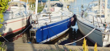 Zarif ve modern yelkenliler yat limanında bir iskeleye demirlediler.. 