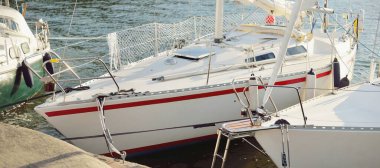 9 metre uzunluğunda, yat limanındaki bir rıhtıma demirlenmiş yelkenli gemi.. 