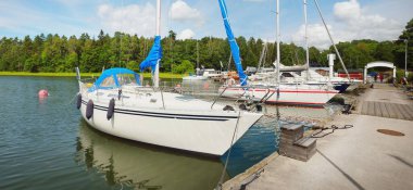 Klasik ve modern yelkenliler yat limanındaki bir rıhtıma demirlediler. Yaz tatilleri, turizm, yat, dinlenme, spor, boş zaman aktiviteleri, hizmet, yaşam tarzı